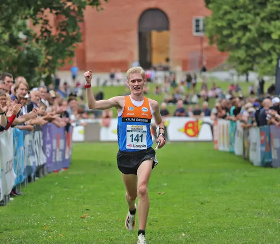 Jonatan Gustafsson sträcker handen i luften efter ett nytt SM-guld i sprint. 