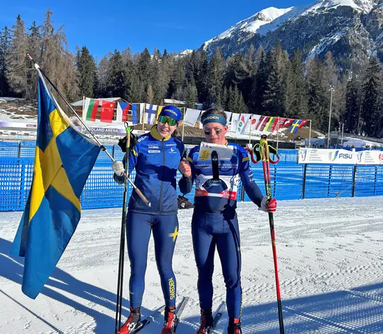 Elin Schagerström och Jonatan Ståhl med svenska flaggan efter segern på mixstafetten vid Student-VM.