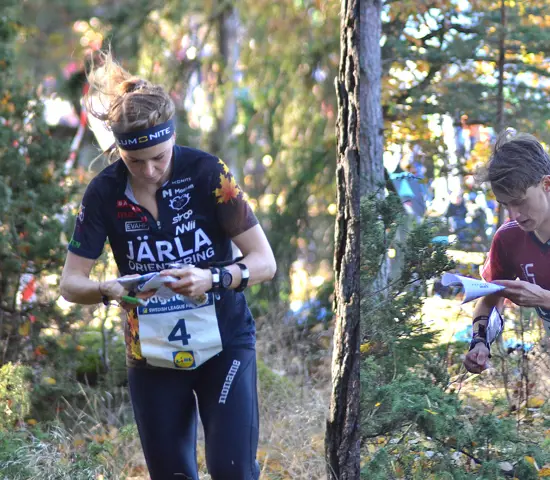 Karolin Ohlsson och August Mollén springer i skogen under koncentrerad kartläsning.